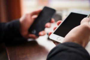 A user holds a smartphone in each hand.